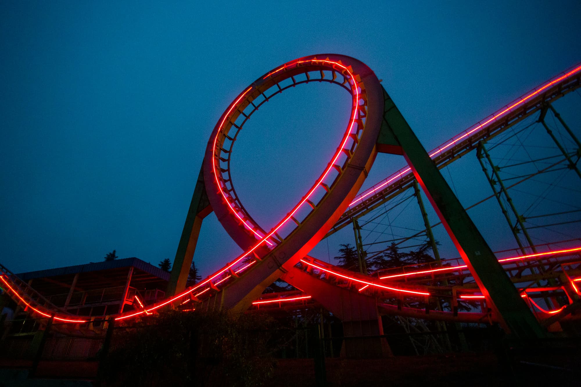 A roller coaster lit up at night with red lights to indicate continuous feedback